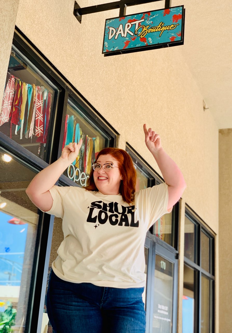 Leslie pointing to Dart Boutique sign