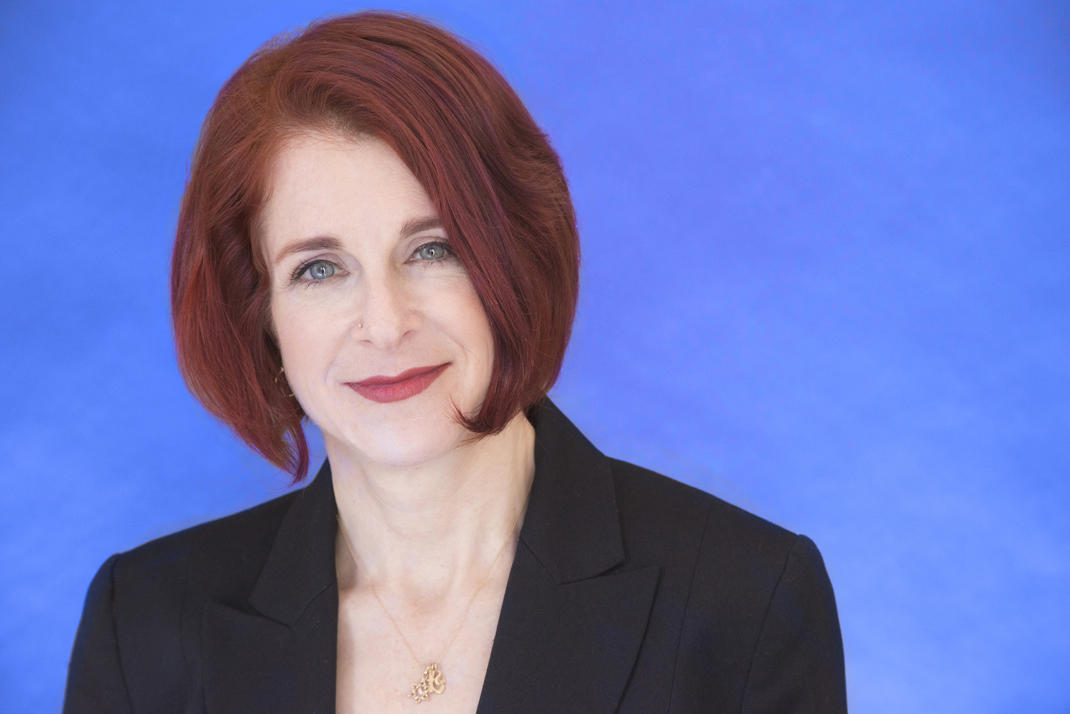 Lynn Harris headshot with blue background. 