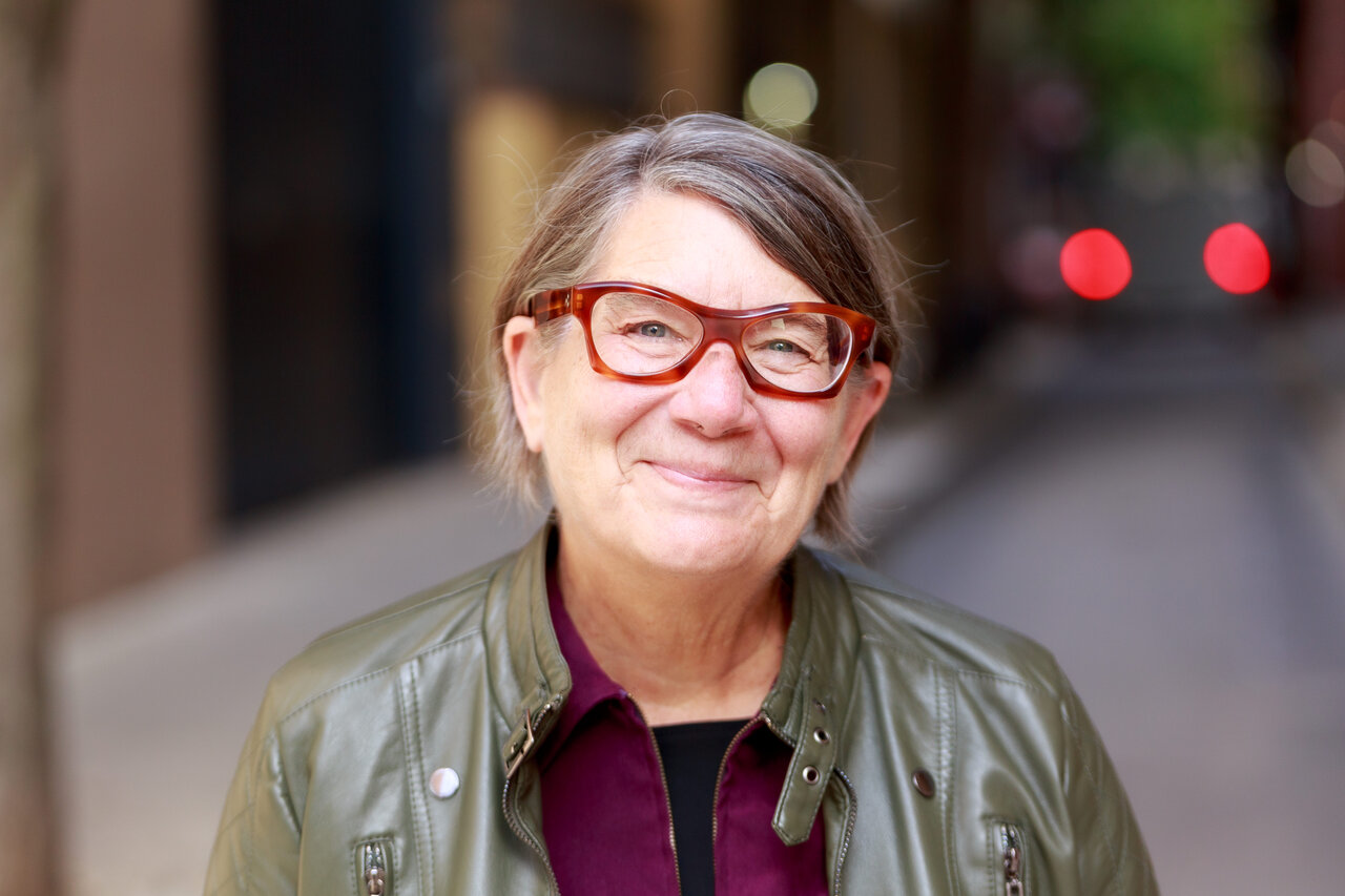 Headshot of Kathy Anderson wearing glasses and a green jacket
